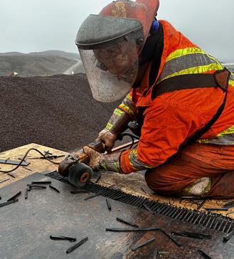 Field User wearing a safety vest and working on a steel cord belt. Prepping for FXC installation.